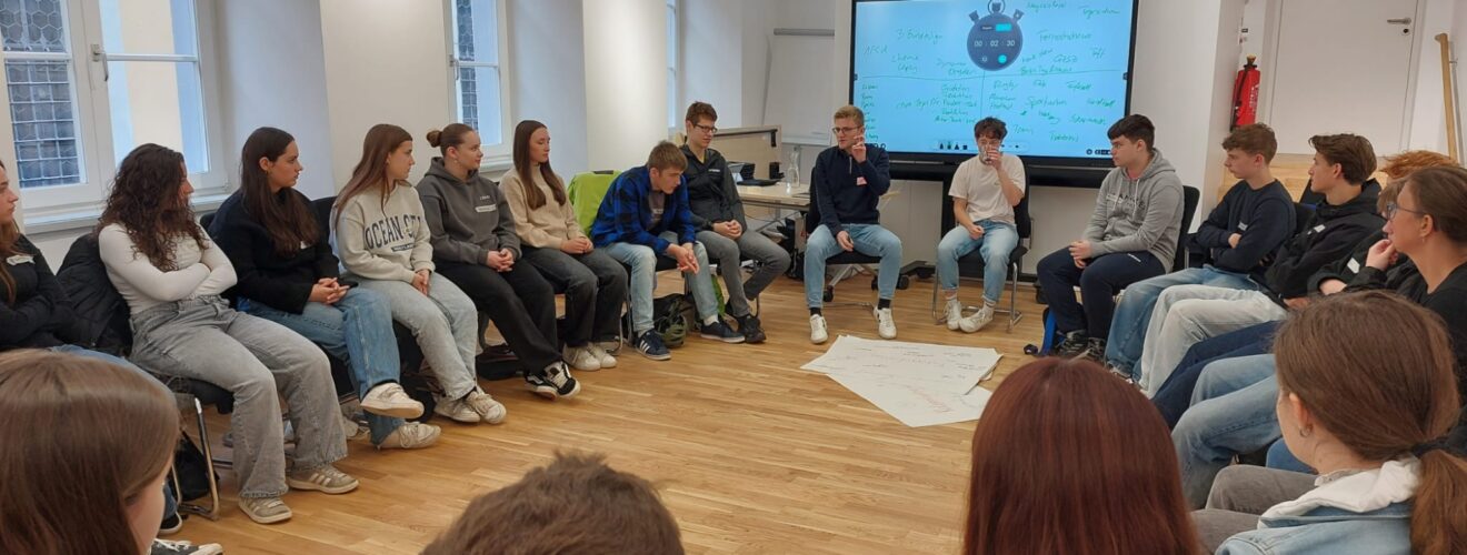 Schüler sitzen im Stuhlkreis