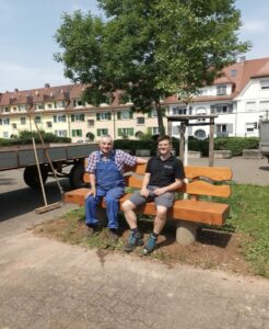 zwei Männer sitzen auf einer Holzbank