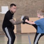 Schüler und Trainer üben Selbstverteidigung